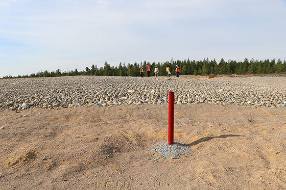 A red pipe stands out of neatly groomed sand and gravel at the remediated landfill at the Bullmoose Mine site.