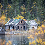 A weathered wooden cabin on the river bank.