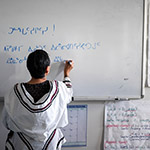Leena écrit en inuktitut (syllabique) sur un tableau blanc dans une salle de classe du centre Pirurvik.