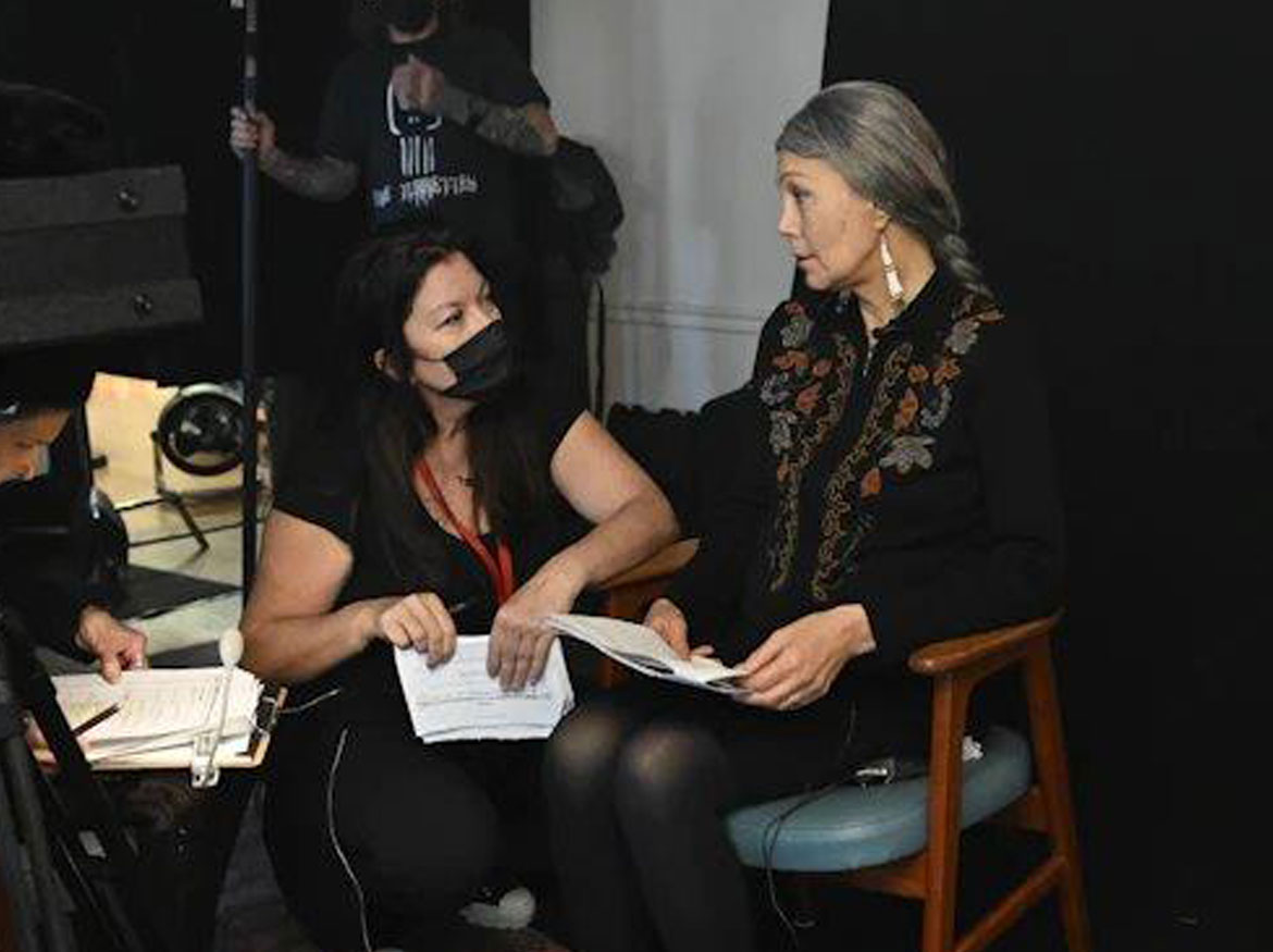 La réalisatrice Marie Clements s'entretient avec un acteur sur le plateau de tournage.