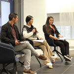 Panelist Jennifer Mierau speaking into a microphone, alongside Brian Pottle and Taylor Behn-Tsakoza