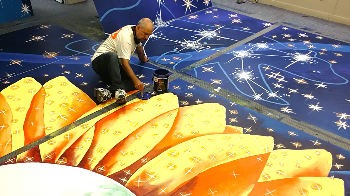 Knowledge Keeper from Iraq, artist Mowafak Alrasam painting the sunflower