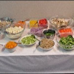 Une table où sont disposés divers bols contenant des ingrédients pour la salade.