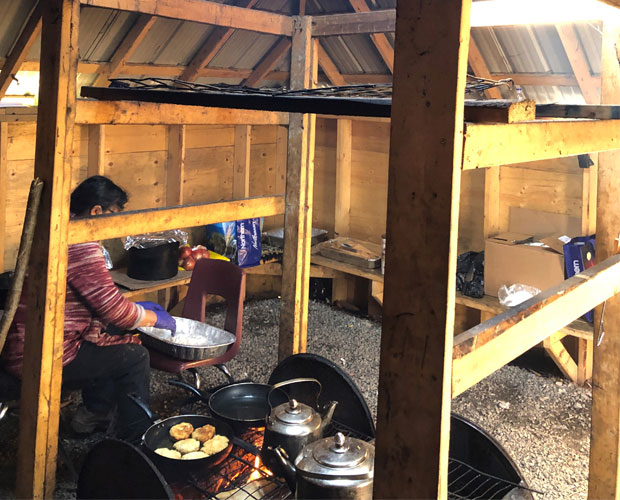 Person cooking food in a community kitchen.