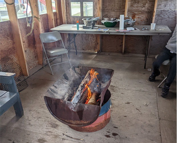 Intérieur de la chambre de fumage d'une communauté nordique comprenant un fumoir au bois, une zone de préparation des aliments et du poisson fumé suspendu au plafond