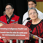 Group of people on stage to announce support for improving Indigenous-led health care for First nations communities.