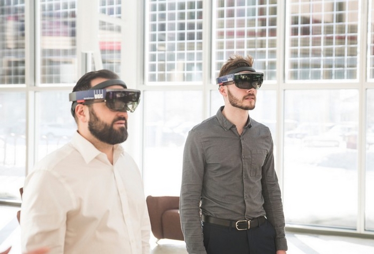 Deux hommes en tenue d'affaires portent des lunettes de réalité virtuelle pour faire l'expérience d'une version virtuelle du site de la mine Giant.