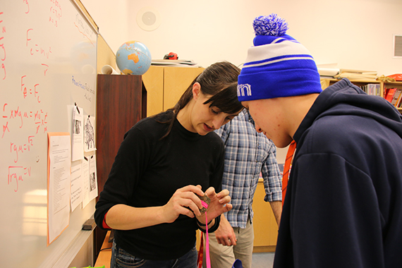 Une agente de projet de l’AANC démontre les propriétés de l’hématite magnétisée à un étudiant.