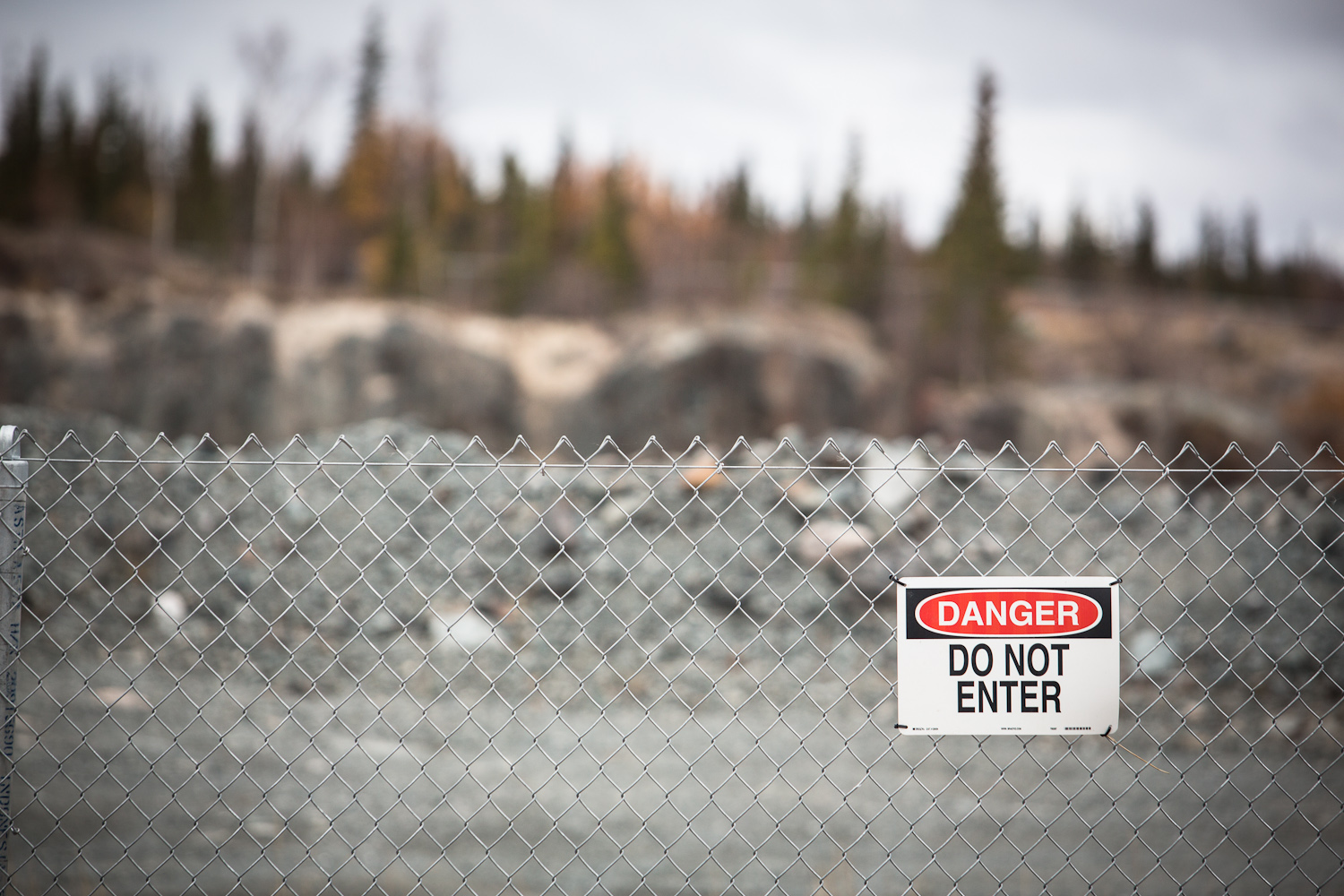 Cette photo montre une clôture à mailles de chaîne avec un panneau indiquant « Danger Do Not Enter » (Danger, ne pas entrer)